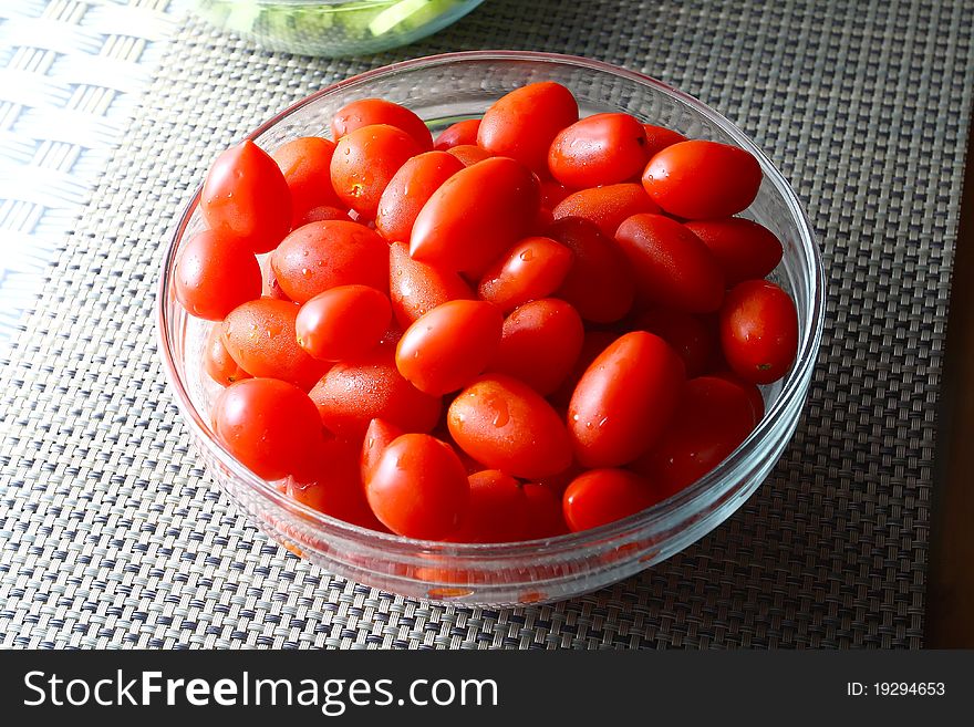 Many deep red tomatoes with green stems, full with antioxidants