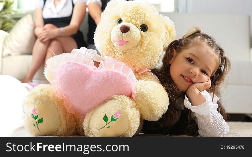 Little girl is hugging big bear