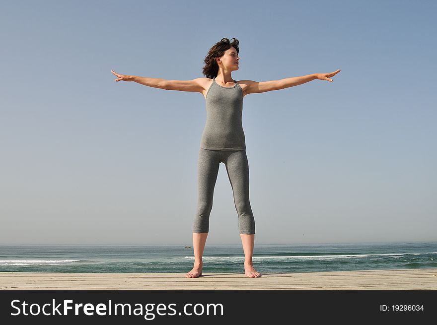 Image of the young woman making exercises on the beach. Image of the young woman making exercises on the beach