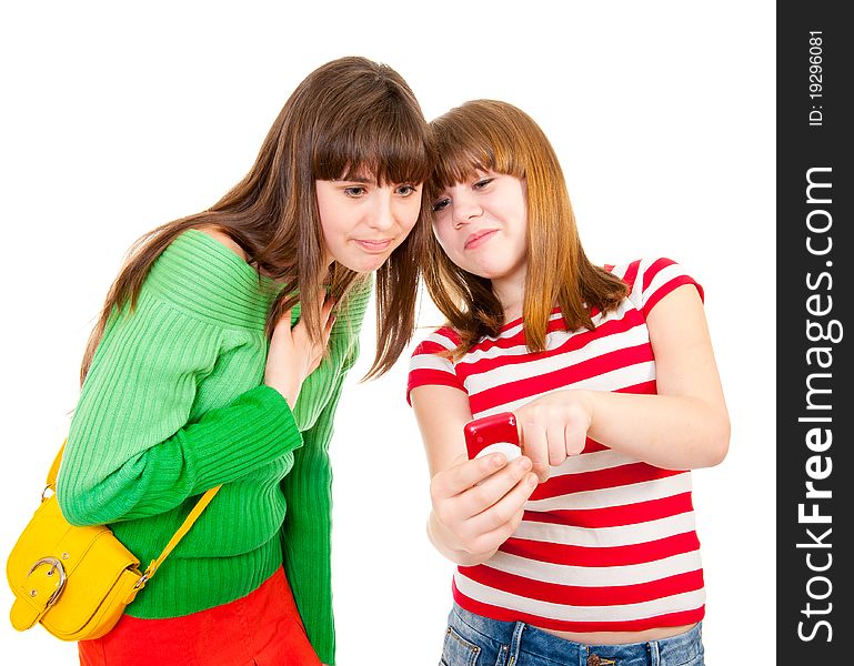 Two schoolgirls watching something in the mobile phone isolated