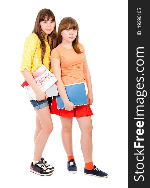 Two schoolgirls teenagers with notebooks isolated over white