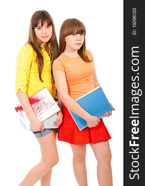 Two schoolgirls teenagers with notebooks isolated over white