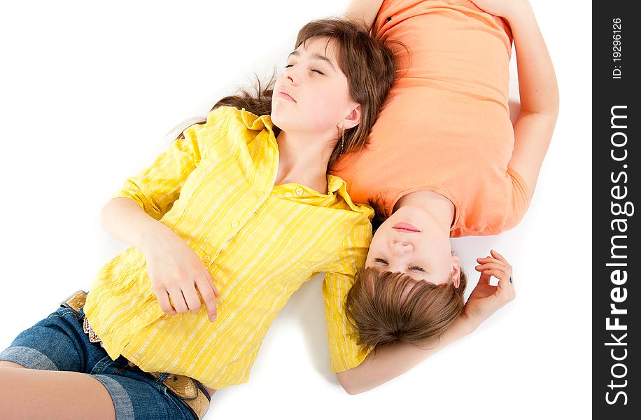 Two teen girls lie side by side isolated on white