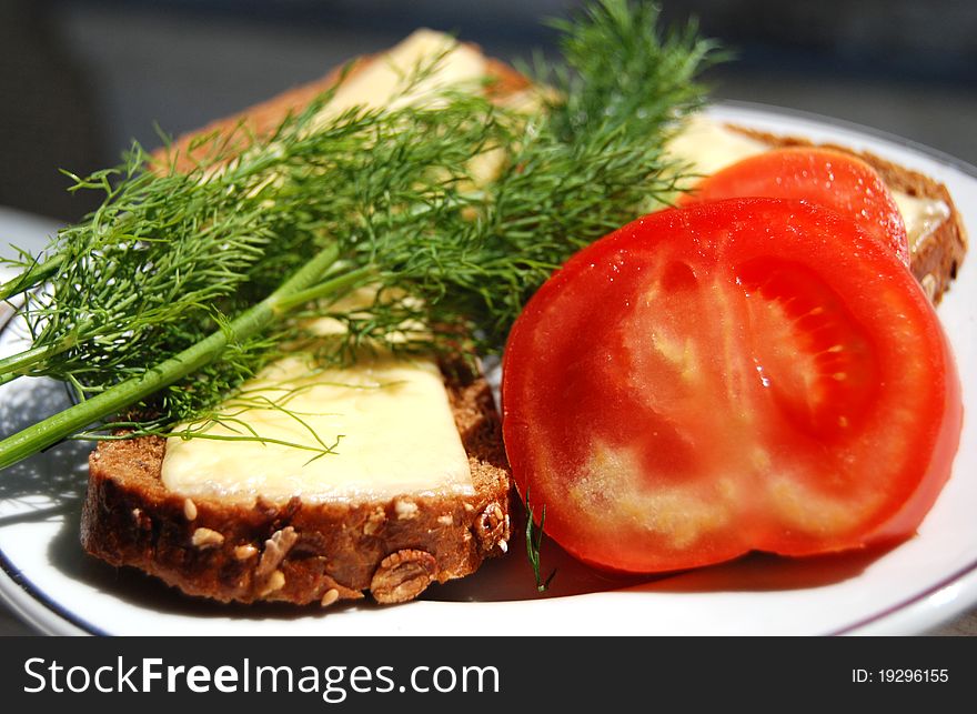 Tasty cheese sandwich, tomato and fresh dill on a plate, lunch. Tasty cheese sandwich, tomato and fresh dill on a plate, lunch