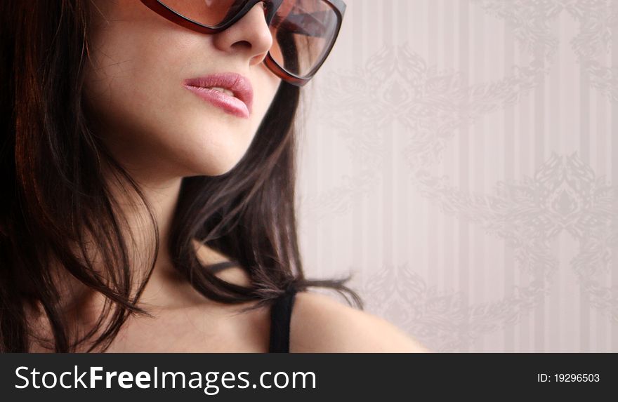 woman in sunglasses on a floral wallpaper background. woman in sunglasses on a floral wallpaper background