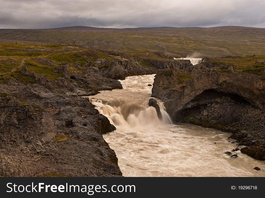 Godafoss waterfalls with mountain in Iceland. Famous touristic attraction. Godafoss waterfalls with mountain in Iceland. Famous touristic attraction