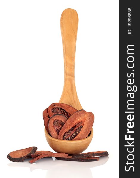 Dried quince fruit in an olive wood ladle and loose, isolated over white background. Used in chinese herbal medicine. Mu gua . Cortex montan radix.