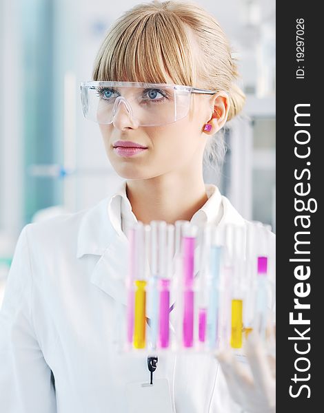 Female researcher holding up a test tube in lab