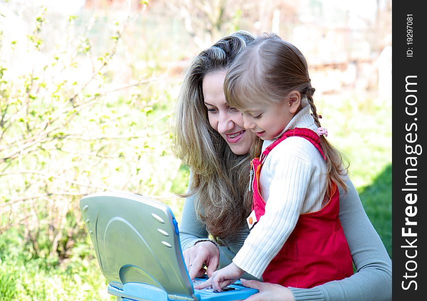 Mother and daughter outdoor with a notebook