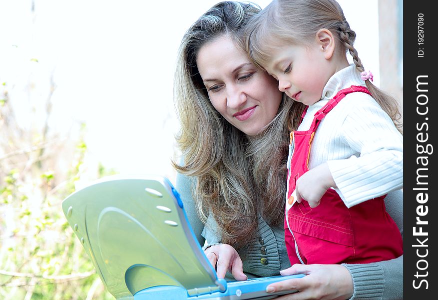 Mother and daughter outdoor with a notebook