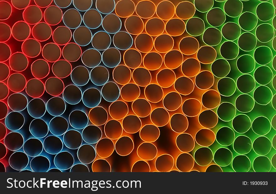 Macro shot of one end of drinking straws, a pack of red, green, blue and orange colored straws. Macro shot of one end of drinking straws, a pack of red, green, blue and orange colored straws