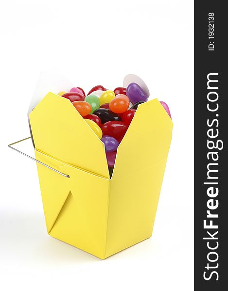 Colorful jellybeans in a yellow takeout container. Colorful jellybeans in a yellow takeout container.