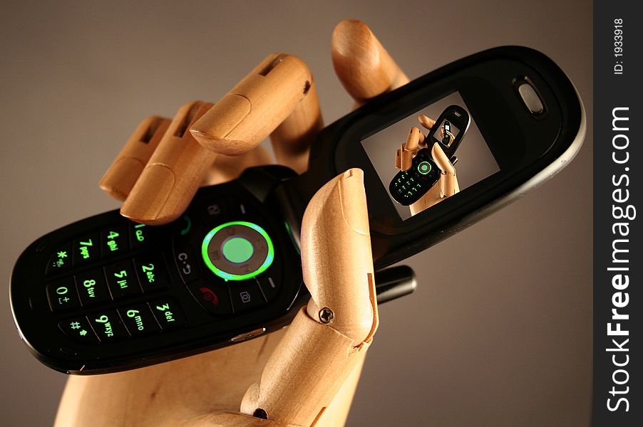 Cellular Phone in a wooden hand. Cellular Phone in a wooden hand.