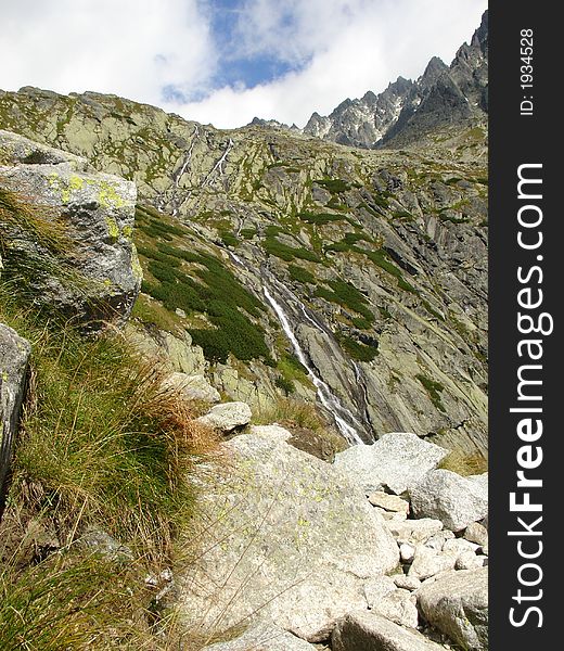 Waterfall at mountains with blue and clouds sky. Hihg Tatra. Waterfall at mountains with blue and clouds sky. Hihg Tatra