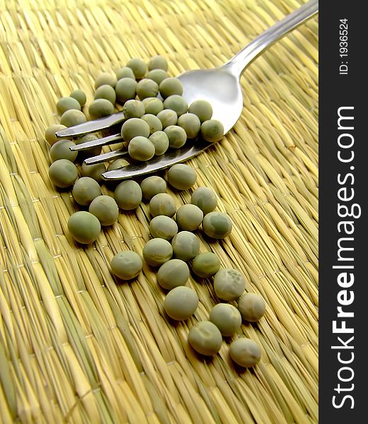 A nice collage of peas and a fork lying on a straw underground. Nice earthly collors. A nice collage of peas and a fork lying on a straw underground. Nice earthly collors