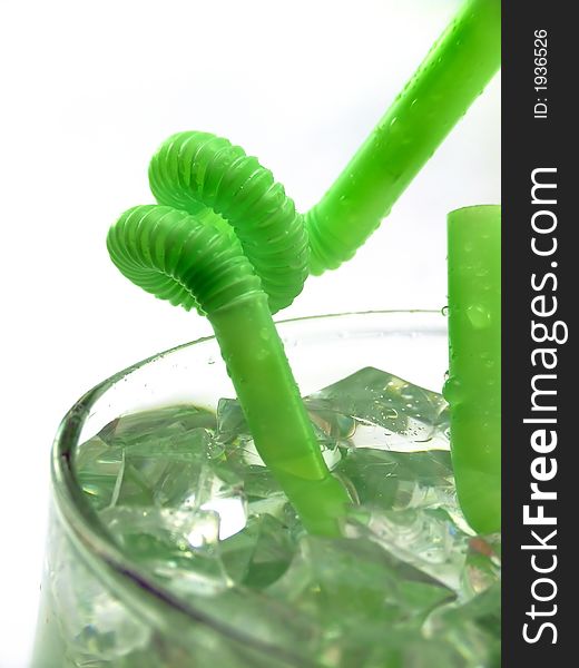 A macro shot of a bended straw, standing in a cold green drink.