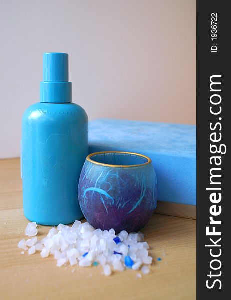 Blue lotion bottle and bath salts and candle for a relaxing spa or bathroom treatment. Blue lotion bottle and bath salts and candle for a relaxing spa or bathroom treatment