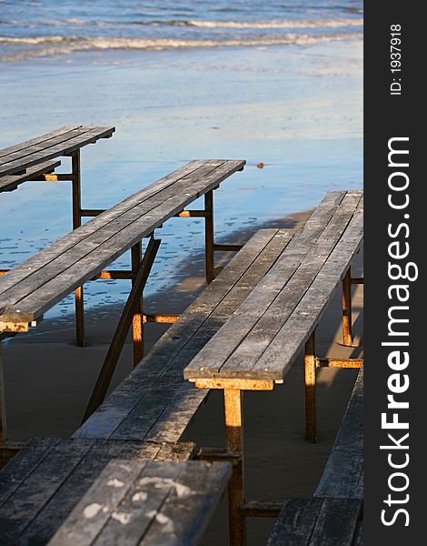 The image of wooden benches on a beach