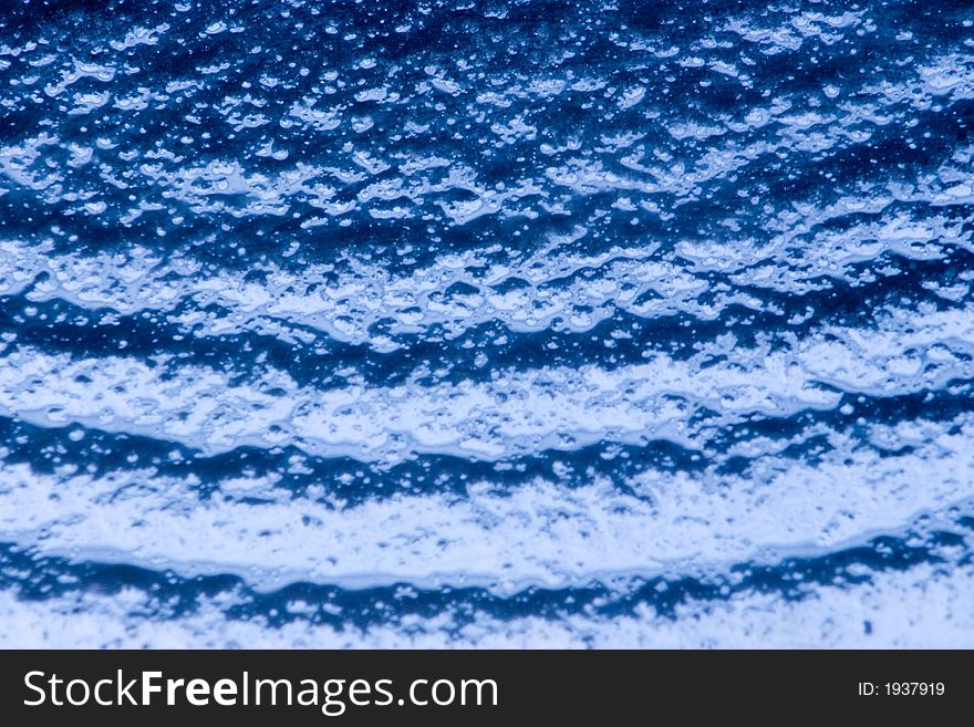 Detail of a bubbled glass with blu natural gradient. Detail of a bubbled glass with blu natural gradient