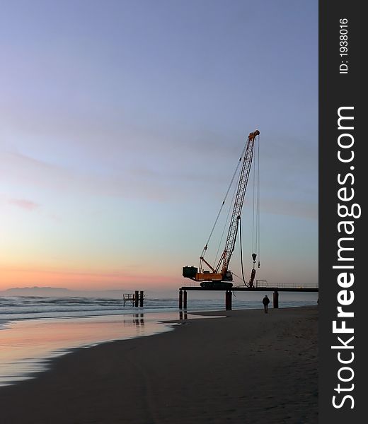 A building machine is left in the coast near the sea. A building machine is left in the coast near the sea