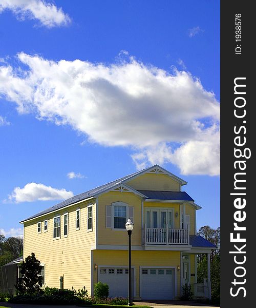 2-story yellow american dream home against perfect blue sky and garage. 2-story yellow american dream home against perfect blue sky and garage