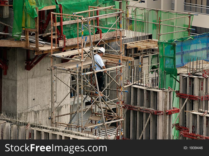 Site supervisor inspecting work at a construction site for high-rise residential apartment block. Site supervisor inspecting work at a construction site for high-rise residential apartment block