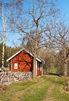 Stone Wall And A Typical Red House In Sweden. Royalty Free Stock Images