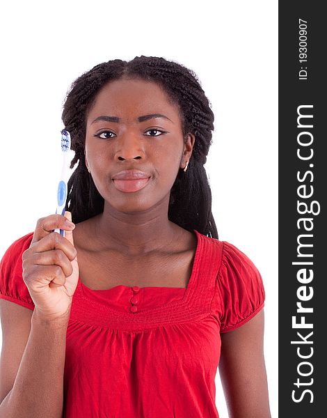 A young black woman with a toothbrush in her hand. A young black woman with a toothbrush in her hand