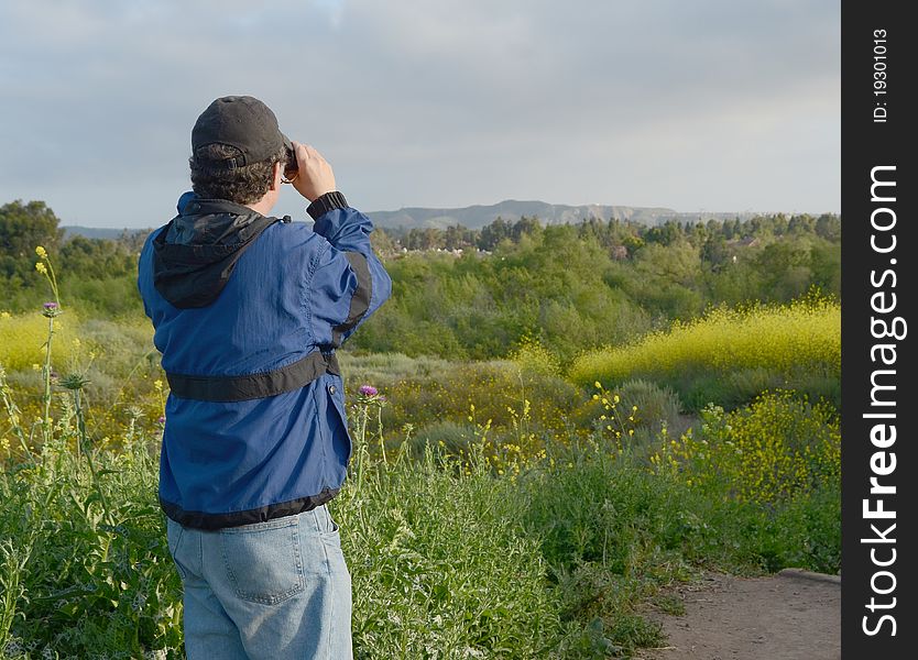 Person on a hike looking through field glasses. Person on a hike looking through field glasses