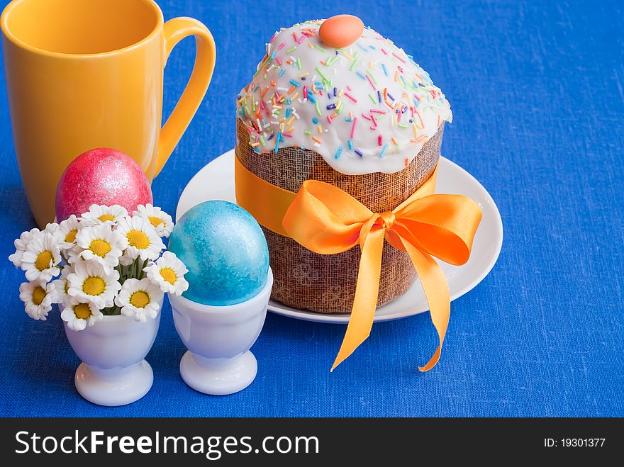 Easter: cake and eggs on blue linen tablecloth, selective focus. Easter: cake and eggs on blue linen tablecloth, selective focus.