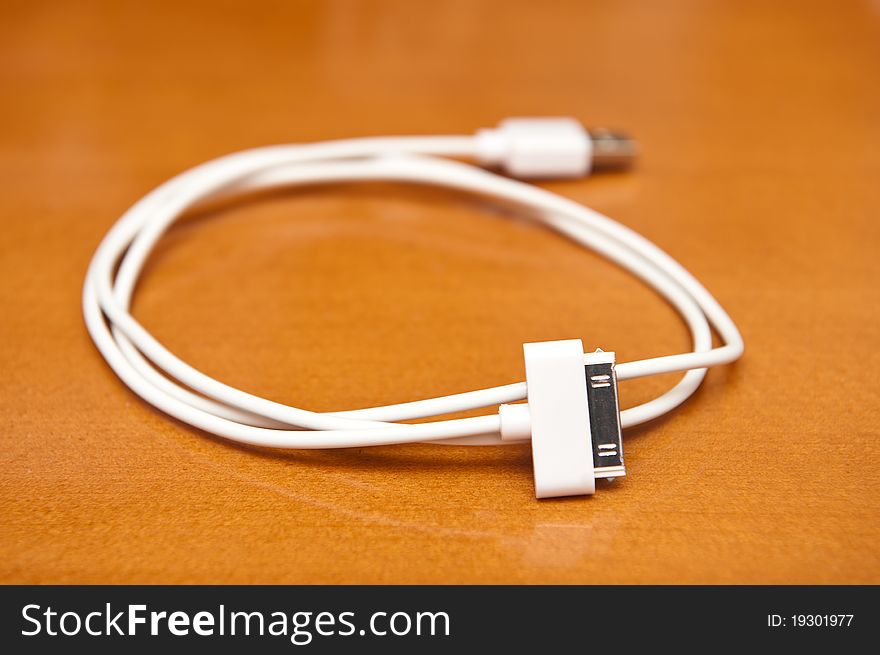 Rolled white USB cable on the desk