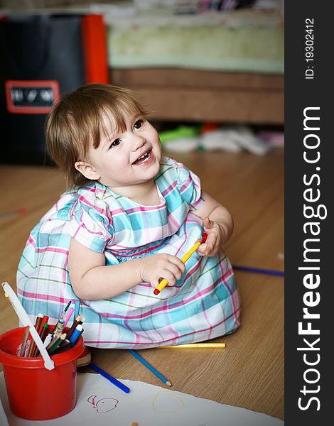 Happy cute baby girl in beautiful dress playing with pens. Happy cute baby girl in beautiful dress playing with pens