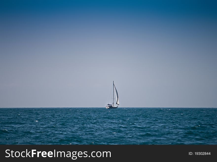 Lonely sailboat in deep sea