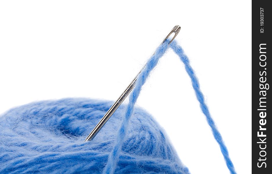 Close-up thread clew with needle, isolated on white