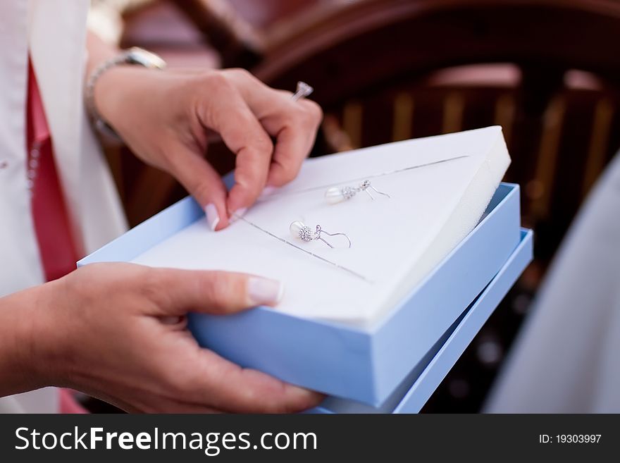 Bride holding earring in presents box