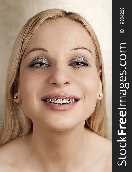 Woman with braces on a golden background