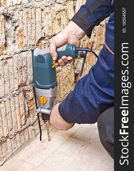 Builder hold perforator and drilling brick wall. Builder hold perforator and drilling brick wall