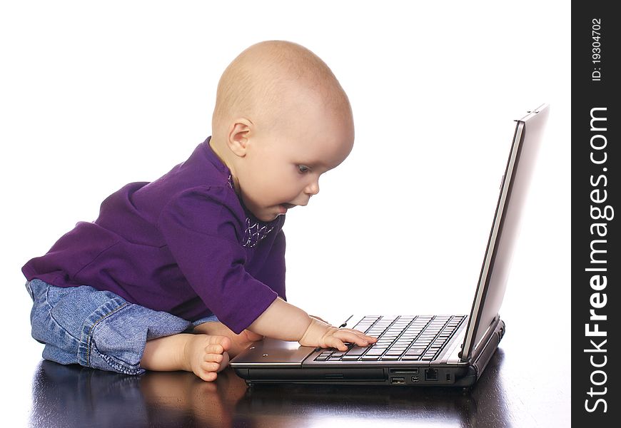 Infant girl looking at the computer as if she has discovered something important. Infant girl looking at the computer as if she has discovered something important