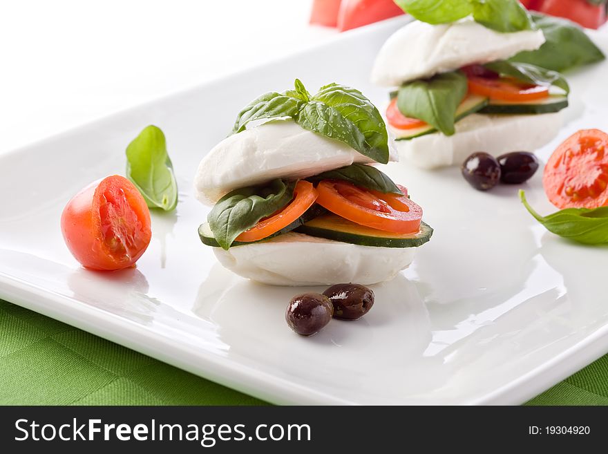 Photo of delicious stuffed mozzarella sandwich with oil and basil