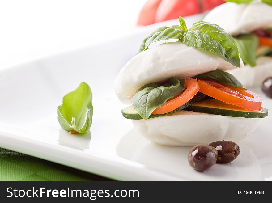 Photo of delicious stuffed mozzarella sandwich with oil and basil