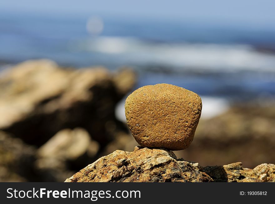 A rock balanced on top of another rock formation on the coast of Newport Beach,CA. A rock balanced on top of another rock formation on the coast of Newport Beach,CA.