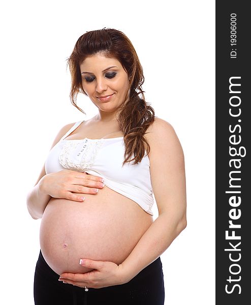 Pregnant woman holding her bare belly isolated on white