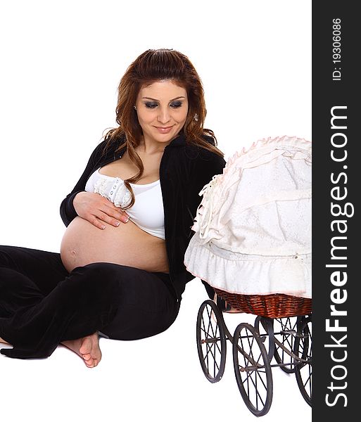 Happy pregnant woman touching her belly and looking at the carriage