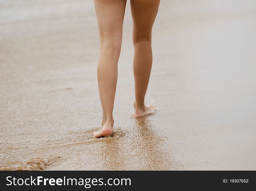 Girl's barefooted legs on a beach. Girl's barefooted legs on a beach