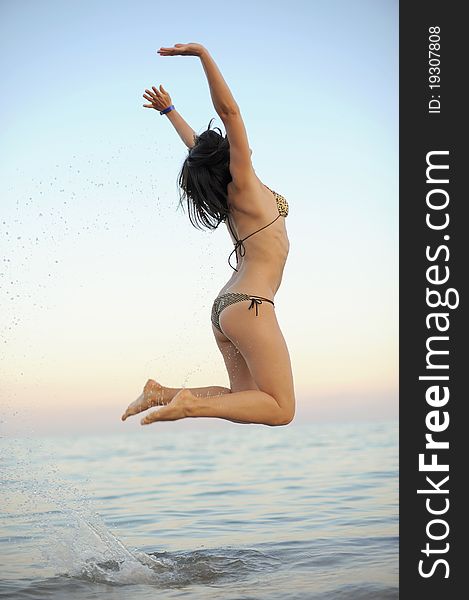 Young woman is jumping in the sea with splashes. Young woman is jumping in the sea with splashes