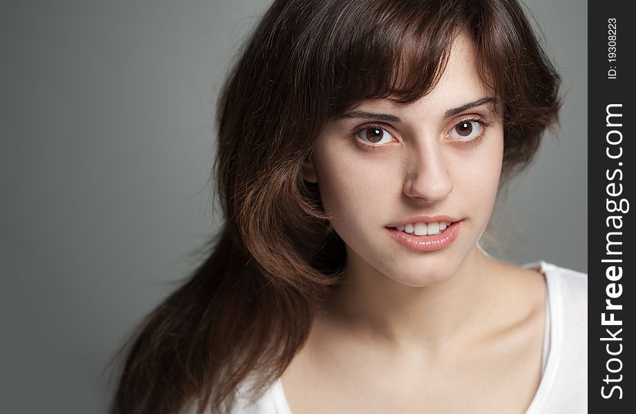 Close up portrait smiling girl on a grey background