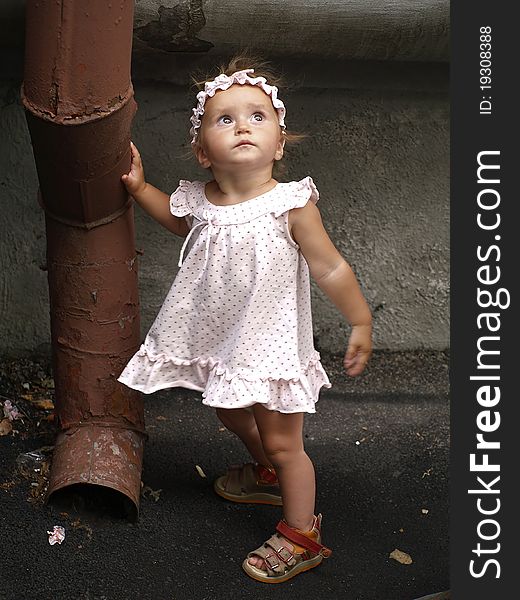 Toddler girl and rainwater pipe