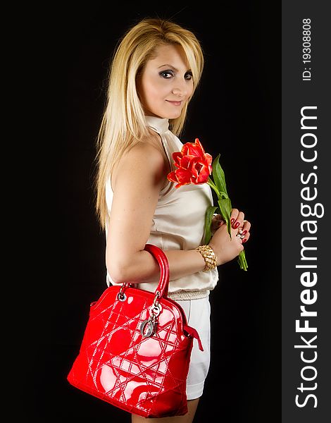 Stylish Woman with red tulips on black background