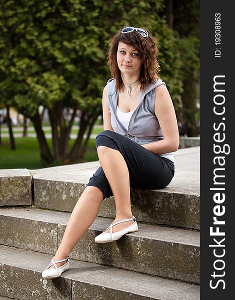 Young woman sitting on stairs, outdoor