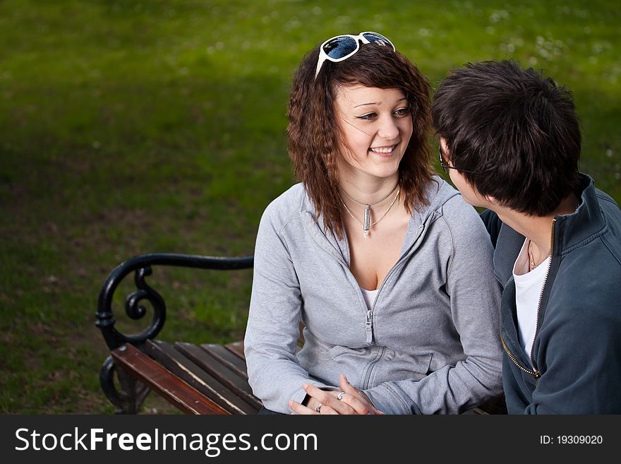 Attractive couple sitting on bench in the park